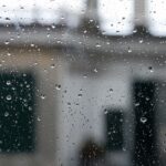 Capture of raindrops on a window with blurred Italian architecture in the background.